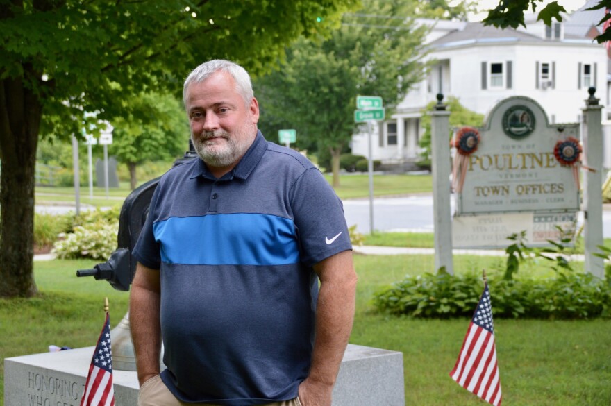 A man stands in front of Poultney Town sign