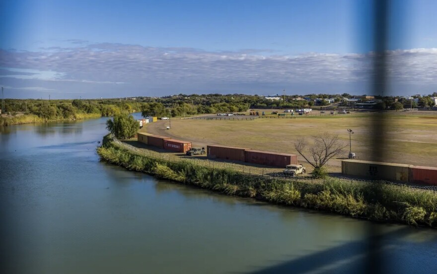 A row of shipping containers and razor wire placed on the banks of the Rio Grande by Gov. Greg Abbott to form a makeshift border wall in Eagle Pass on Nov. 19, 2021.