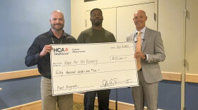 Randy Stevens and Ethan Lendore of Hope for NH Recovery accept a check from CMC Chief Executive Officer John Skevington.