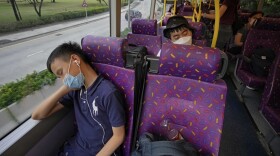 Passengers sleep on the upper deck of a double-decker bus in Hong Kong on Saturday.