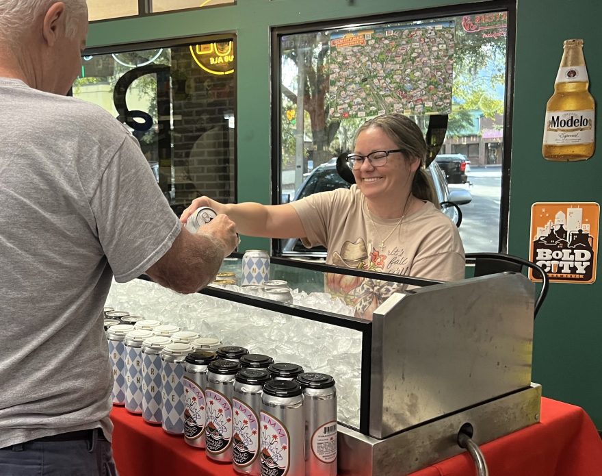 Brittney Brunson, a manager at Crafty Bastards, pours Gary Winner, 70, a sample of beer to try at the restaurant’s beer tasting event every Thursday at The Bottle Shoppe. (Keira Shoaf/WUFT News)