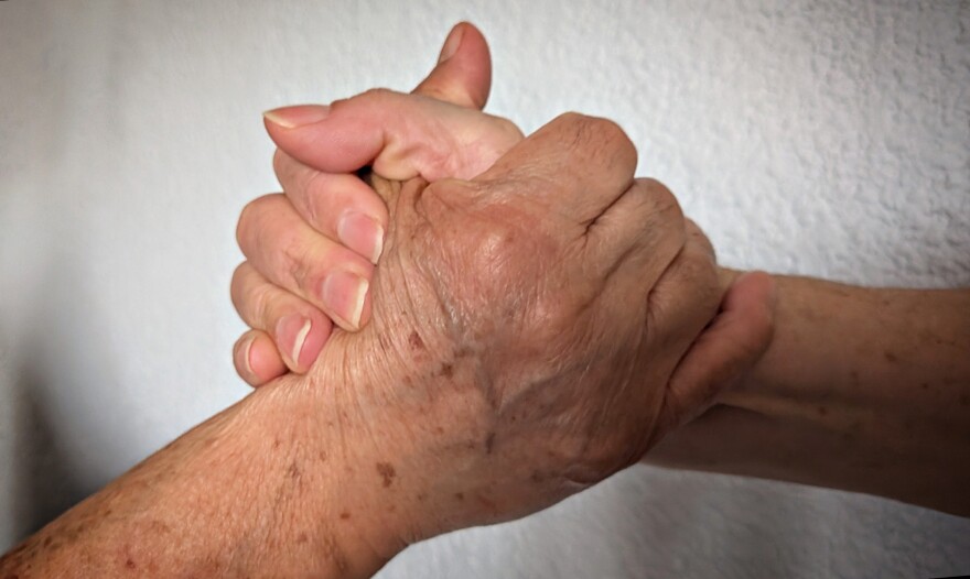 Amelia y su hija Raquel se toman de la mano.