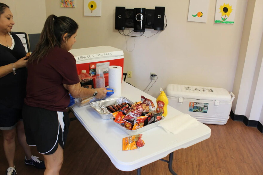 Assistant Manager Joann Olveda prepares hot dogs for residents of the Ernest C. Olivares Senior Community on Sunday.