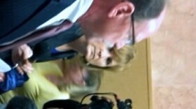 District Attorney Tim Harris discusses the case with reporters in the courthouse hall way.
