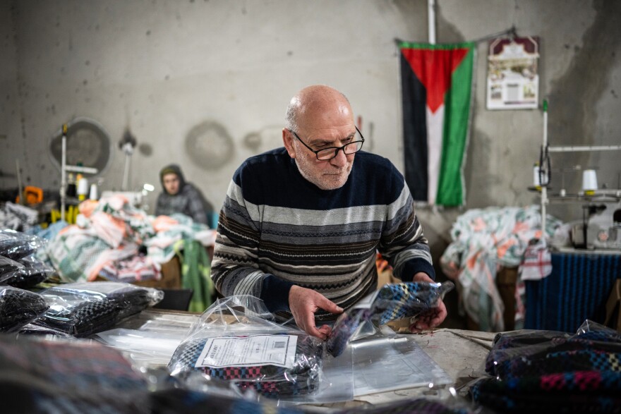 Judeh Hirbawi packages keffiyehs at the Hirbawi keffiyeh factory, which has seen an increase in sales since the start of the Israel-Hamas war, in Hebron, West Bank, on Feb. 11, 2024. Hirbawi is one of three brothers who own and run the factory that their father started.