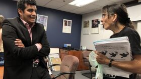 City Commissioner David Arreola and Alachua County Labor Coalition Membership Coordinator Sheila Payne chat after the subcommittee meeting May 15. Payne holds a bag of her organization's buttons that she gave away at the meeting. (Danielle Ivanov/WUFT News)