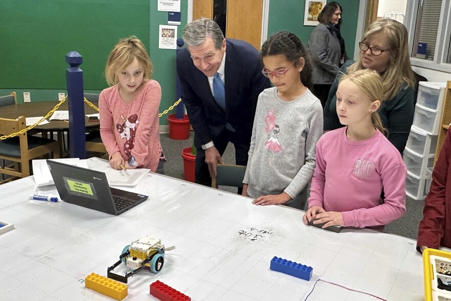 North Carolina Gov. Roy Cooper, center left, watches a robotics team at Nashville Elementary School in Nashville, N.C., direct its vehicle in the school library, Tuesday, Jan. 23, 2024. Cooper came to his old school to officially proclaim 2024 as "The Year of Public Schools" and to begin an effort in his final year in office to push his favored education policy preferences at the General Assembly (AP Photo/Gary D. Robertson)