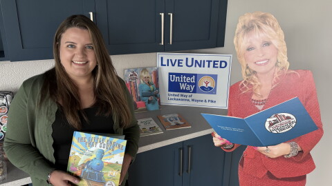 Angela Bassani, President & CEO of United Way of Lackawanna, Wayne & Pike, holds one of the first books children receive from Dolly Parton's Imagination Library. The United Way runs the local chapter of the library program.