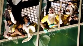 Six inmates at the City Justice Center look out the shattered glass windows of the of the downtown St. Louis jail. 