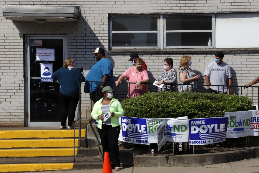 Voters stand in line as they wait to cast their ballots during primary voting in Braddock, Pa., on Tuesday. Problems with absentee ballots and a smaller number of polling places led to long lines in several states as primary elections that were delayed by the coronavirus resumed.