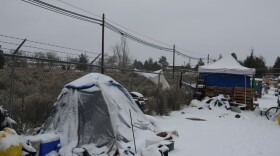 A person occupies a snow-covered tent on the outskirts of Bend, as the outside temperature approaches single digits on Dec. 29, 2021.