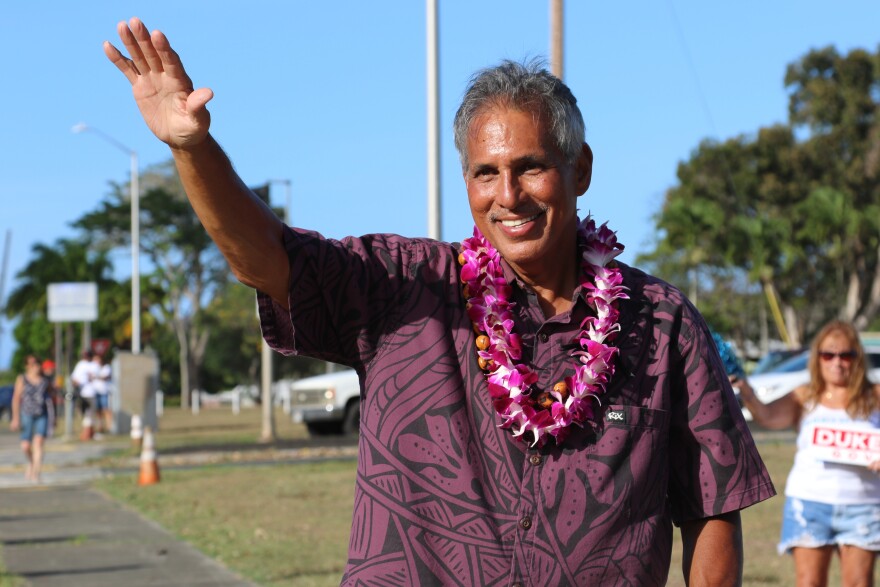 Former Lt. Gov. James R. "Duke" Aiona waves at passing cars while campaigning in Kailua, Hawaiʻi on Aug. 9, 2022. (AP Photo/Audrey McAvoy)