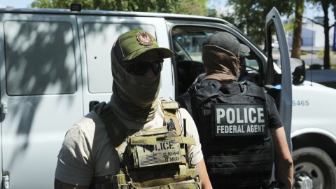 ICE and HSI police protect a van after taking into custody a person outside an immigration court Wednesday, May 21, 2025, in Phoenix.