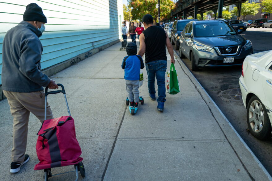 A child joins his father as residents receive food at the St. Helena Pantry in the Bronx in New York City.