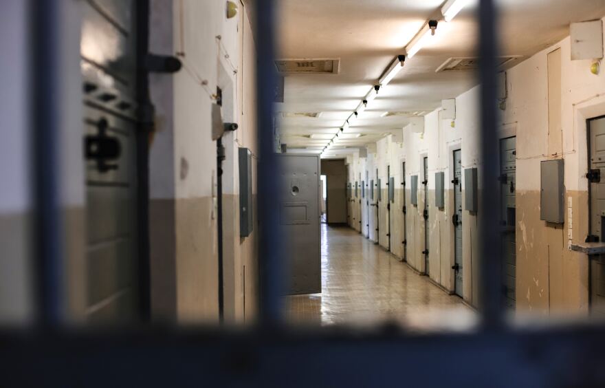 A view of a hallway from a jail cell. 