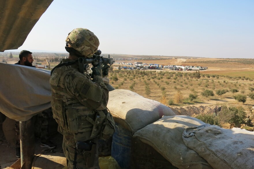 A member of the U.S. Military stands watch at an observation post outside Manbij, near the front-line with Turkish backed forces.