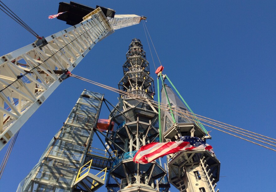 The silver spire is fully installed on One World Trade Center's roof, bringing the structure to its full and symbolic height of 1,776 feet Friday.