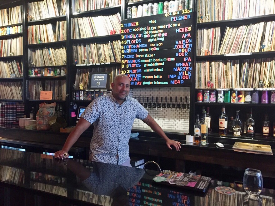 Chris Maestro, the owner of BierWax, stands behind the bar.