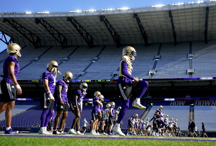 Members of the Washington offense, including quarterback Michael Penix Jr., right, warm up during the NCAA college football team's practice Wednesday, Aug. 2, 2023, in Seattle.