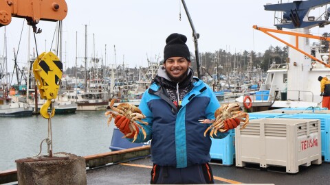 Tyller Hanrahan displays a pair of Dungeness crabs on the dock in Newport on Jan. 27, 2026.