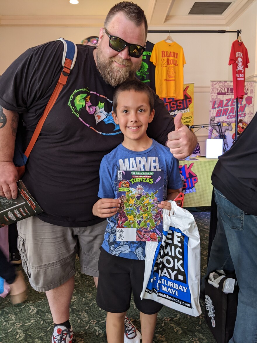 Two Teenage Mutant Ninja Turtles fans from two generations get a signed copy of the comic by Jim Lawson at Rochester and Jet Pack Comics Free Comic Book Day on May 6.