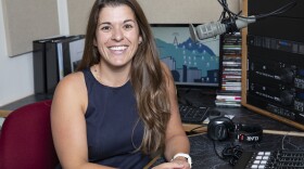 Michelle Matus is in the KUNR studio. She is looking at the camera and smiling.