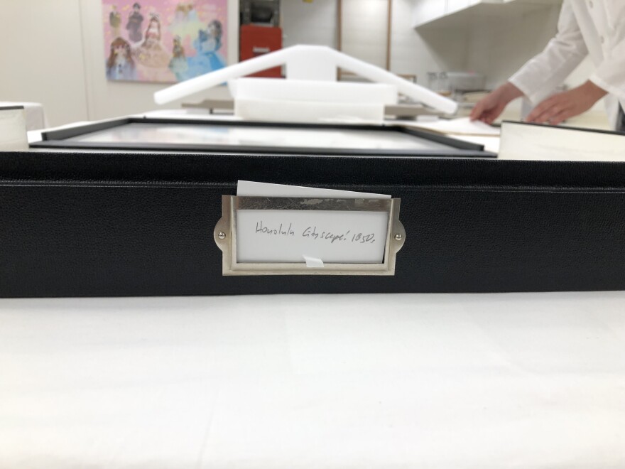 Lithographs of King Kamehameha III's funeral procession are stored in a large black box to preserve and protect them.