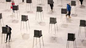 A poll worker walks over to sanitize a voting booth after a voter leaves to walk their ballot over to the machines at Cross Insurance Center on Tuesday, November 3, 2020. (Brianna Soukup/Portland Press Herald via Getty Images)
