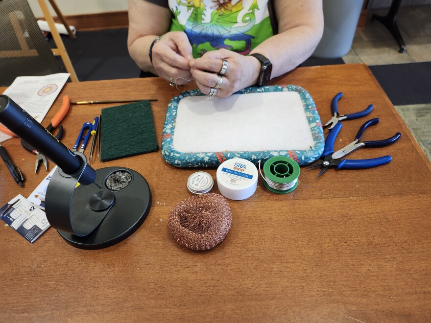 Woman works on jewelry.