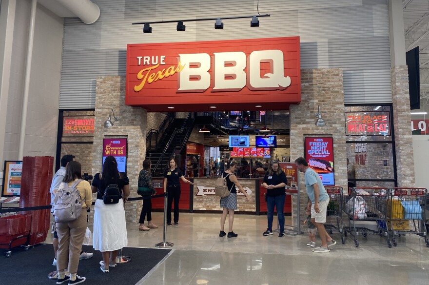 A photo shows a line of people in front of the new H-E-B's True Texas BBQ restaurant.