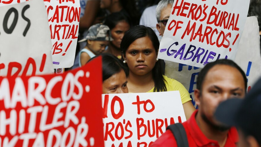 Protesters listen to the ruling of the Philippine Supreme Court allowing the body of late Philippine dictator Ferdinand Marcos to be buried at the country's Heroes' Cemetery.
