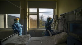 medical staff members check a ventilator