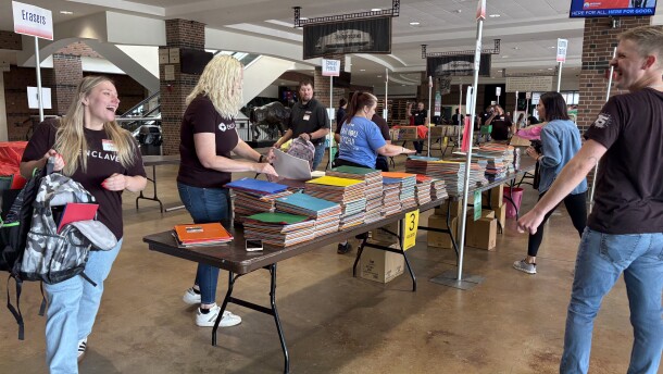 Volunteers from Enclave stuff backpacks for this year's United Way of Cass-Clay's school supply drive.