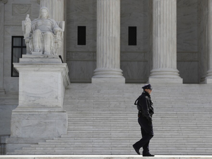 A police officer walks outside the Supreme Court on March 16.