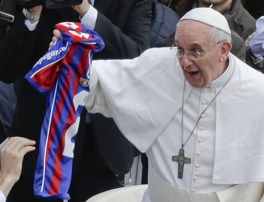 Pope Francis holds a San Lorenzo jersey handed to him at the end of the Easter Mass at the Vatican on March 31, 2013. The pope is an avid fan of the Buenos Aires soccer team.