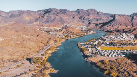 mountains with the colorado river running through it and houses on the banks.