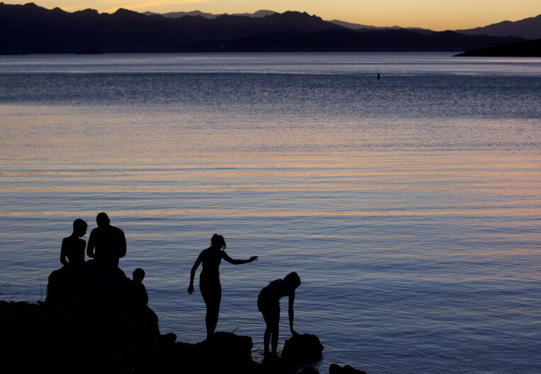 FILE - In this May 27, 2011 file photo, kids fish at twilight at the edge of Kingman Wash, at Lake Mead National Recreation Area in Arizona. Regional health officials say a Las Vegas-area boy died from a rare brain-eating amoeba that investigators think he was exposed to in warm waters at Lake Mead. (AP Photo/Julie Jacobson, File)