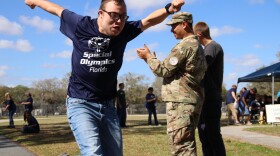A Hillcrest student sprints toward the finish line during the track event on Thursday, March 5, 2026. Volunteers and staff cheer him on from the sidelines.
