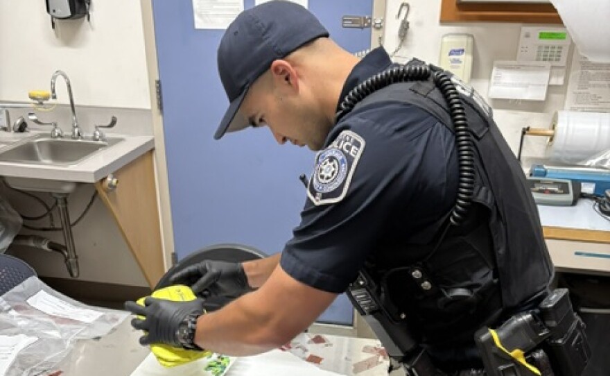 Officer Kawasaki conducting a field drug test on pills found on a suspect