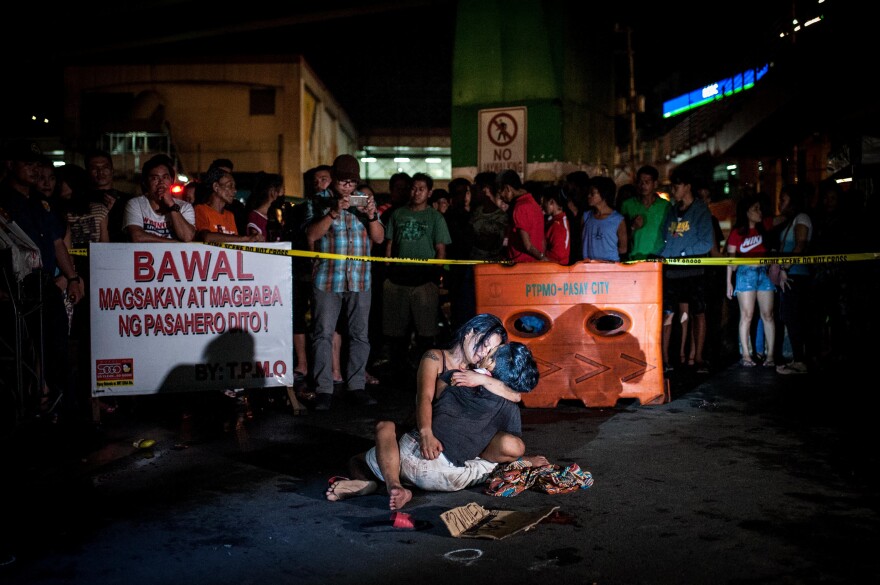 A grieving woman clutches her dead husband after armed assailants shot him in a main thoroughfare in July in Manila, Philippines. The man was accused of being a drug peddler, a claim disputed by his wife, who maintained her husband was nothing more than a pedicab driver plying his trade when he was shot in front of her.