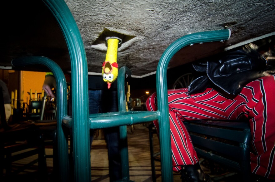 Rubber chicken poking through a hole in a table