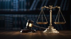 This stock photo shows a gavel and a depiction of the scales of justice.