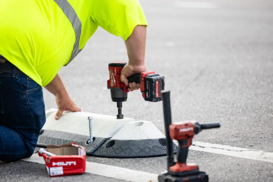 Worker drills in divider on road 