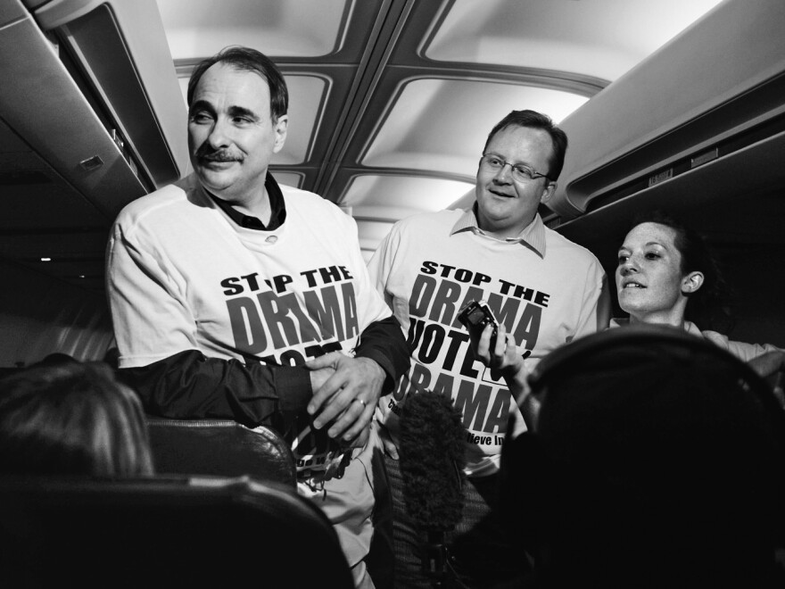 Chief campaign strategist David Axelrod (left) and communications director Robert Gibbs talk to members of the traveling press corps during a flight leading up to the Pennsylvania primary in 2008.