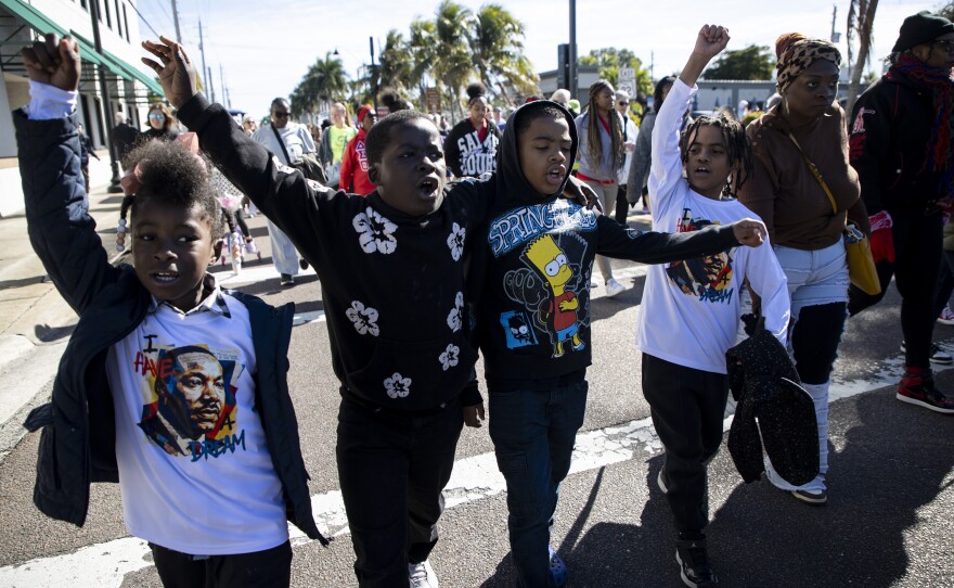 Journey Holloway, left, Mason Holloway, Lorenzo Jones and Louis Moss chant while marching in the Dr. Martin Luther King Jr. Annual Commemorative March on Monday, Jan 19, 2026, in Fort Myers.
