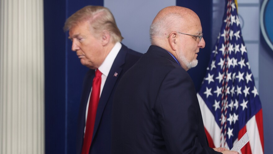 President Trump's administration "is obsessed with magic bullets — vaccines, new medicines, or a hope that the virus will simply disappear," <em>The Lancet</em> says. Trump and CDC Director Robert Redfield attended a coronavirus task force briefing at the White House last month.