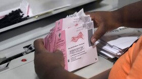 FILE - An election worker prepares mail-in ballots at the Clark County Election Department on Nov. 8, 2022, in Las Vegas.