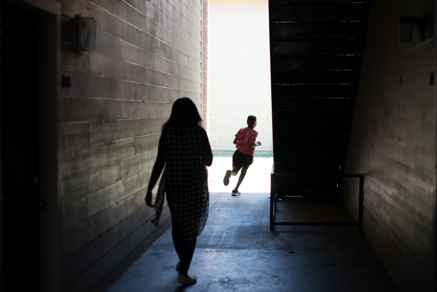 C'Artis Harris' children run off to the playground. Without finding housing to use her Section 8 housing, Harris and her children continue to live with a friend.
