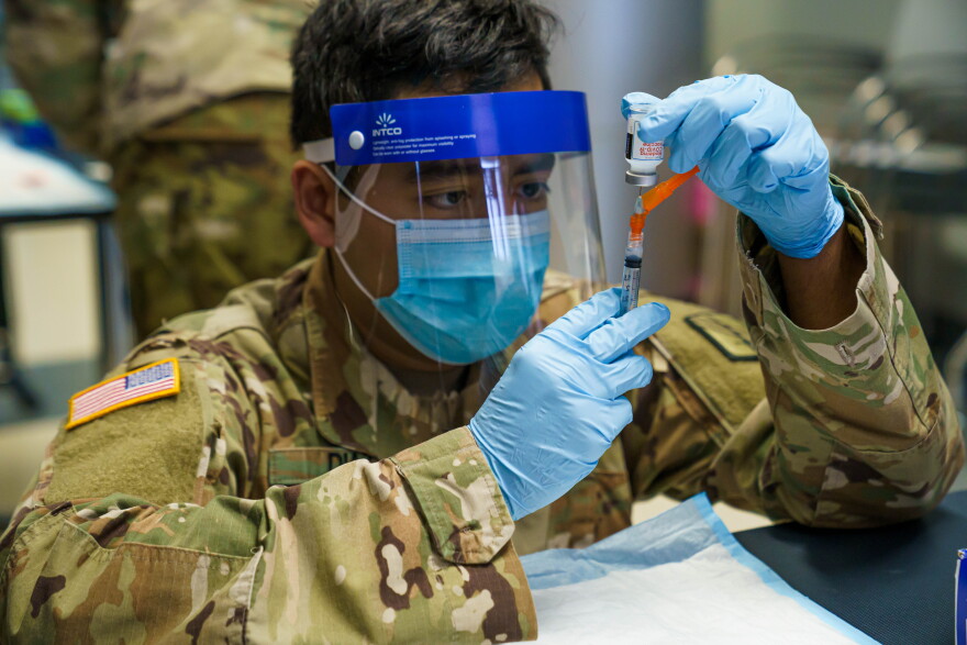 Spc. Larry Diaz assigned to Headquarters Company, 113th Sustainment Brigade, North Carolina National Guard (NCNG) prepares to inoculate NCNG members with COVID-19 vaccine at Joint Force Headquarters in Raleigh, Jan. 8, 2021. These inoculations will help the NCNG defeat the virus, stop the spread of the virus and maintain unit readiness.