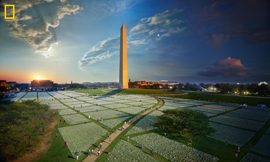 A composite photograph captures the passage of day to night at the "In America: Remember" art installation on the National Mall in Washington, D.C. Each flag represents an American life lost to COVID-19.